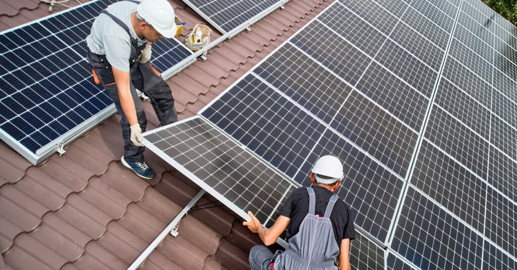 Solar panels being handled during roof work