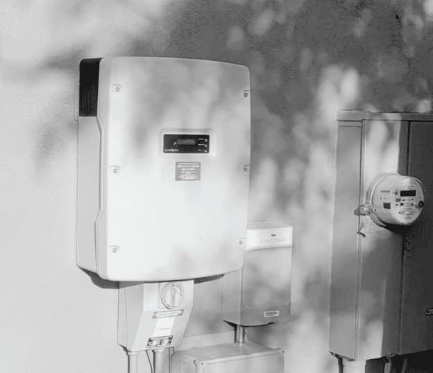 Wall-mounted solar inverter next to a utility meter