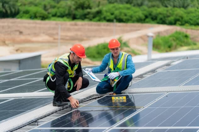 Technicians checking rooftop solar panels